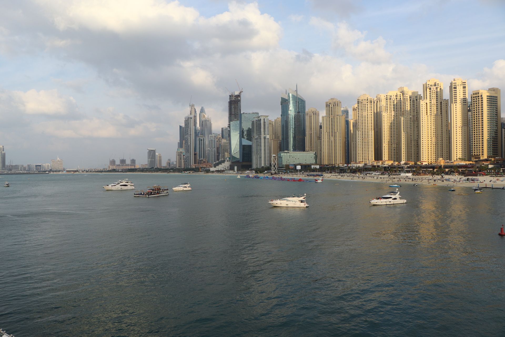 A breathtaking view of Dubai Marina with luxurious skyscrapers and yachts on a sunny day.