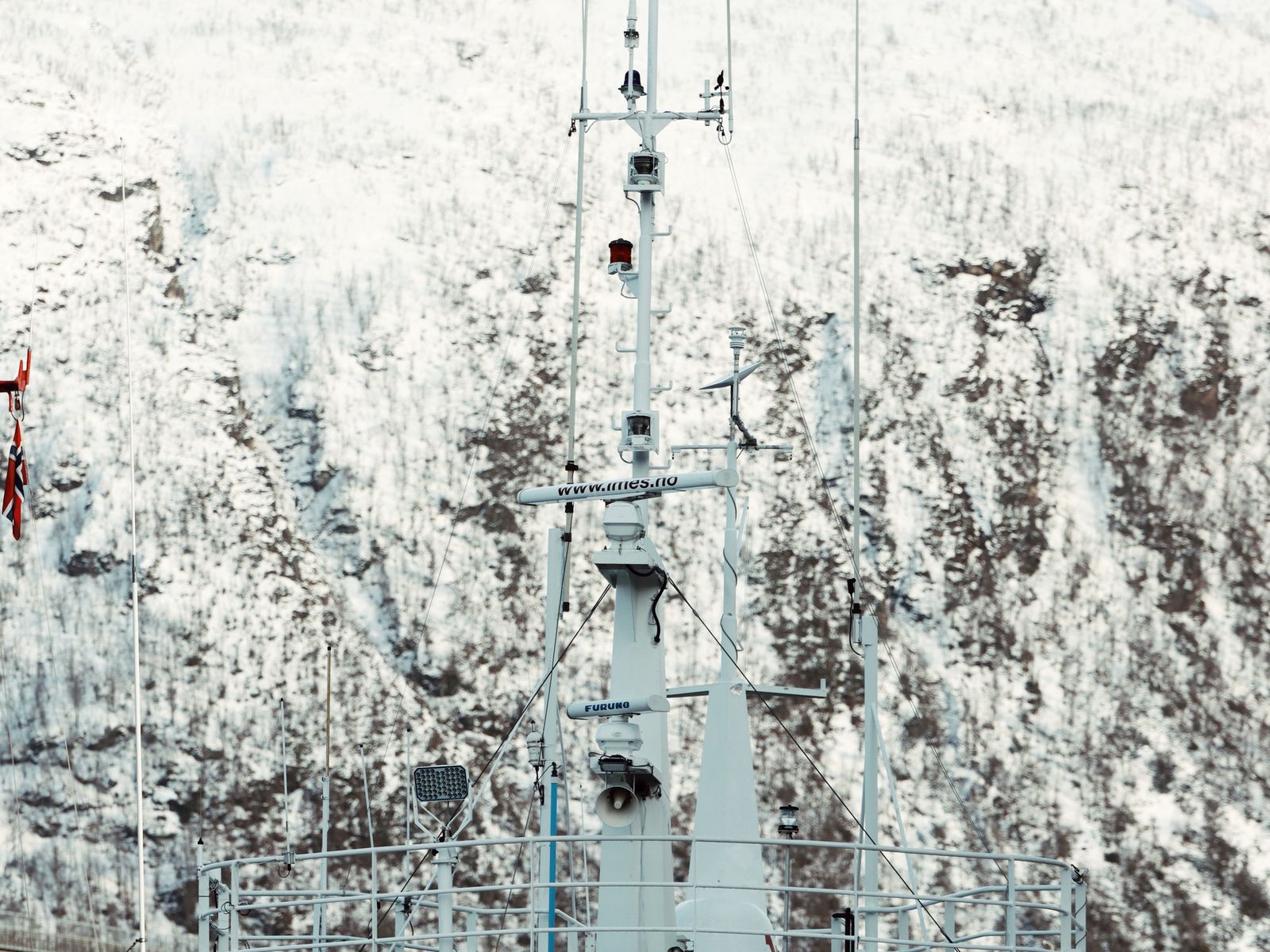 A polar expedition vessel at anchor in the Tromso fjord below snow-covered hills.