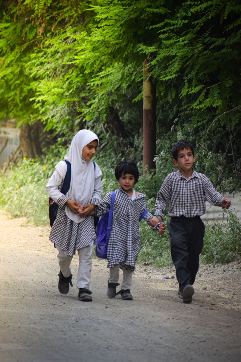 Children in school uniforms with backpacks walking to school