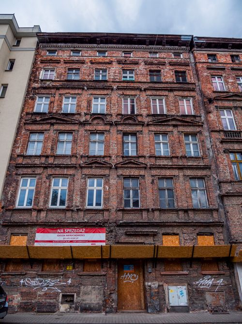 Free Old multi-story brick building with urban charm, featuring a 'For Sale' sign. Stock Photo