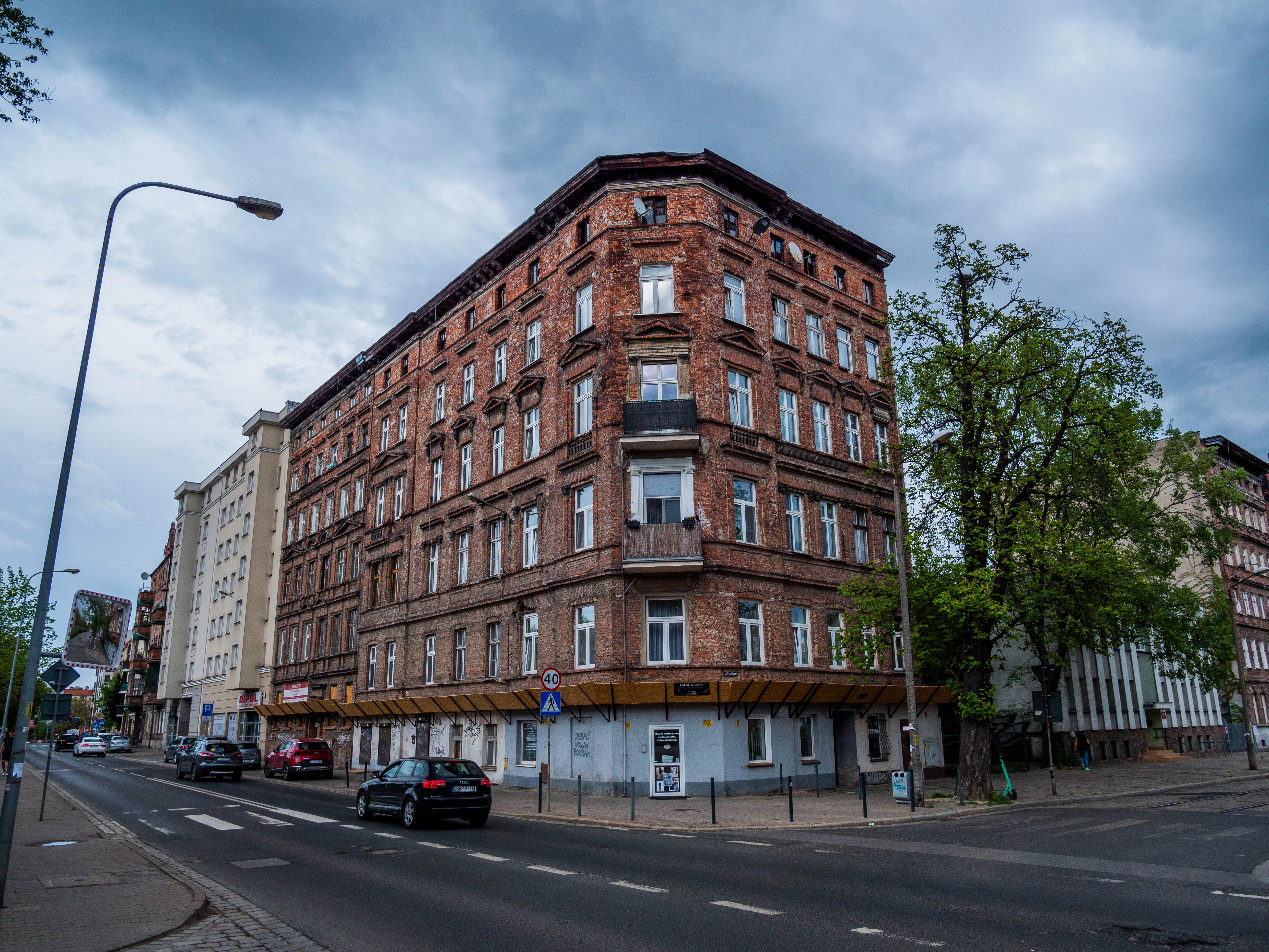Free Old brick building at urban street corner with overcast skies, showcasing traditional architecture. Stock Photo