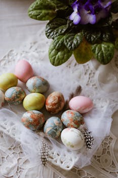 Artistic Easter eggs with floral decorations on lace, symbolizing spring celebration.