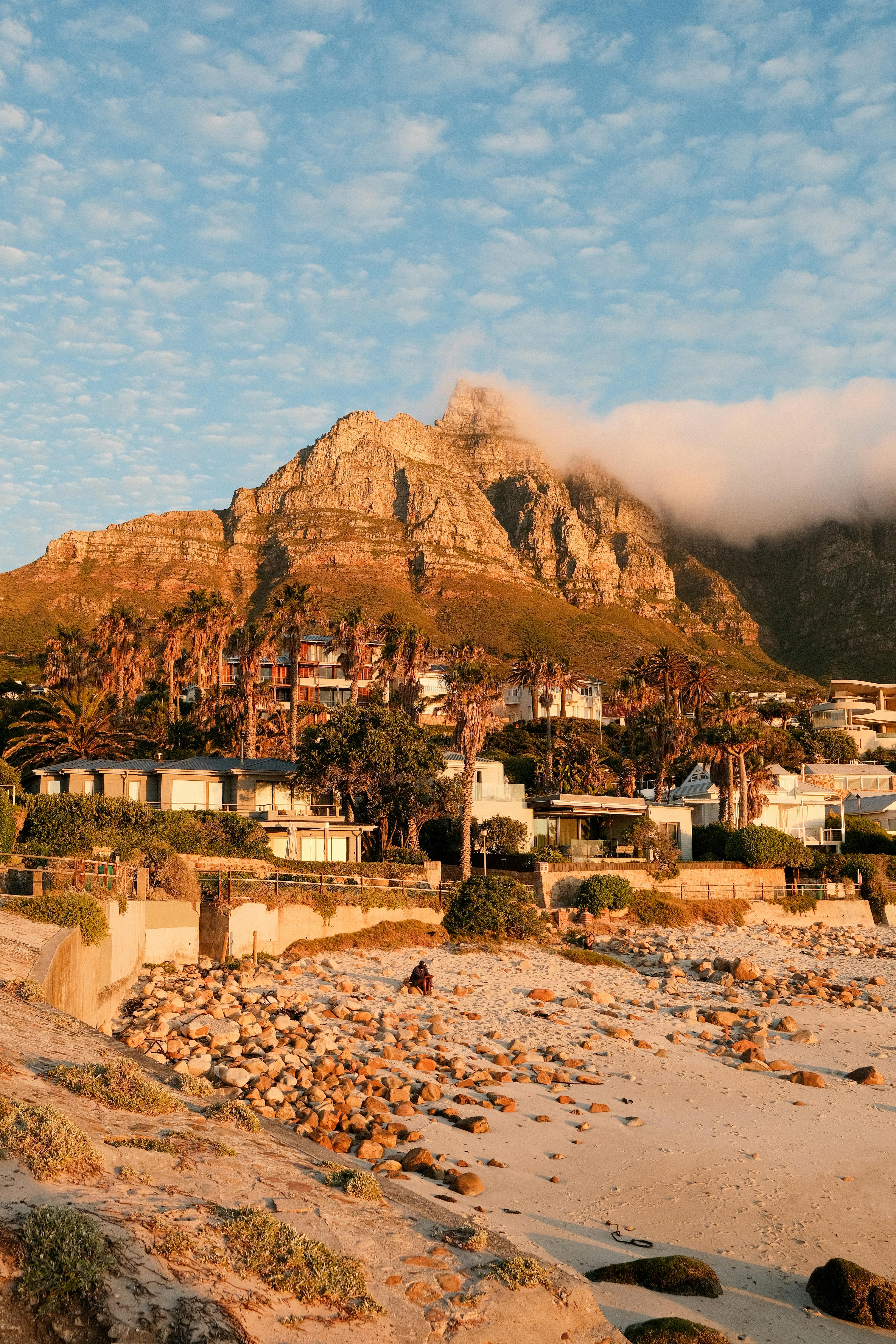Stunning sunset view of Cape Town beach with Table Mountain and residential area.