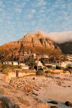 Stunning sunset view of Cape Town beach with Table Mountain and residential area.