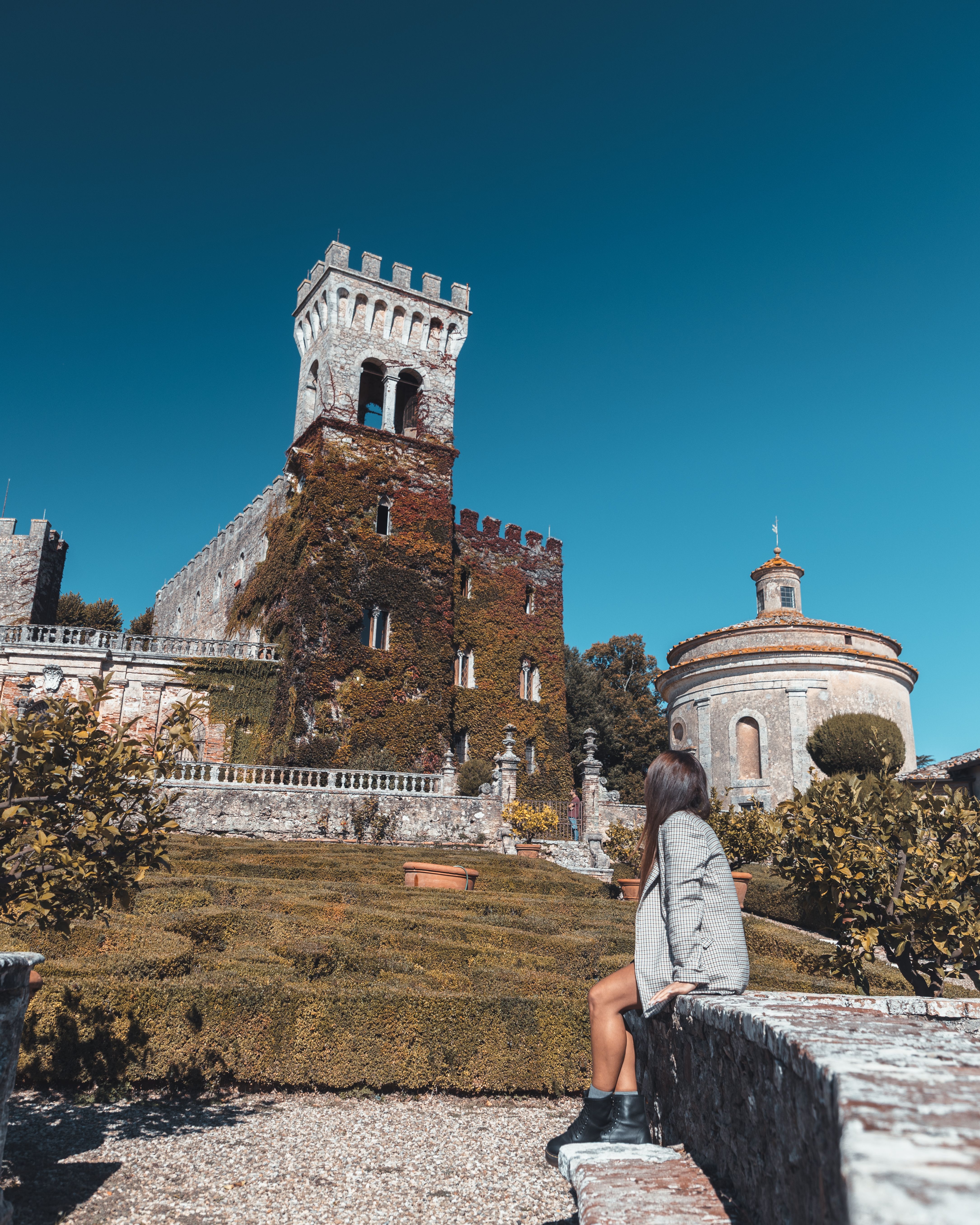 Woman exploring historic castle scenic garden view · Free Stock Photo