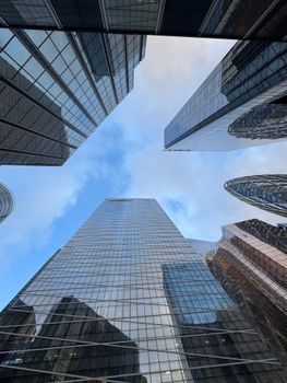 Perspective view of towering glass skyscrapers in La Défense, Paris under a blue sky.