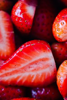 Vibrant red strawberries shown in close-up, including halves, highlighting freshness and texture.
