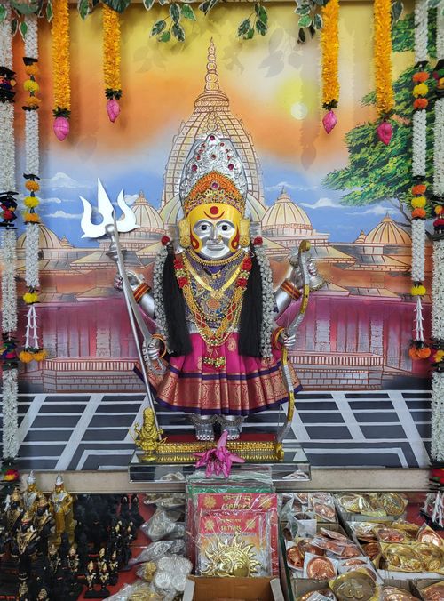 Free Colorful Hindu deity statue in a temple adorned with flowers and decorations, capturing spiritual essence. Stock Photo