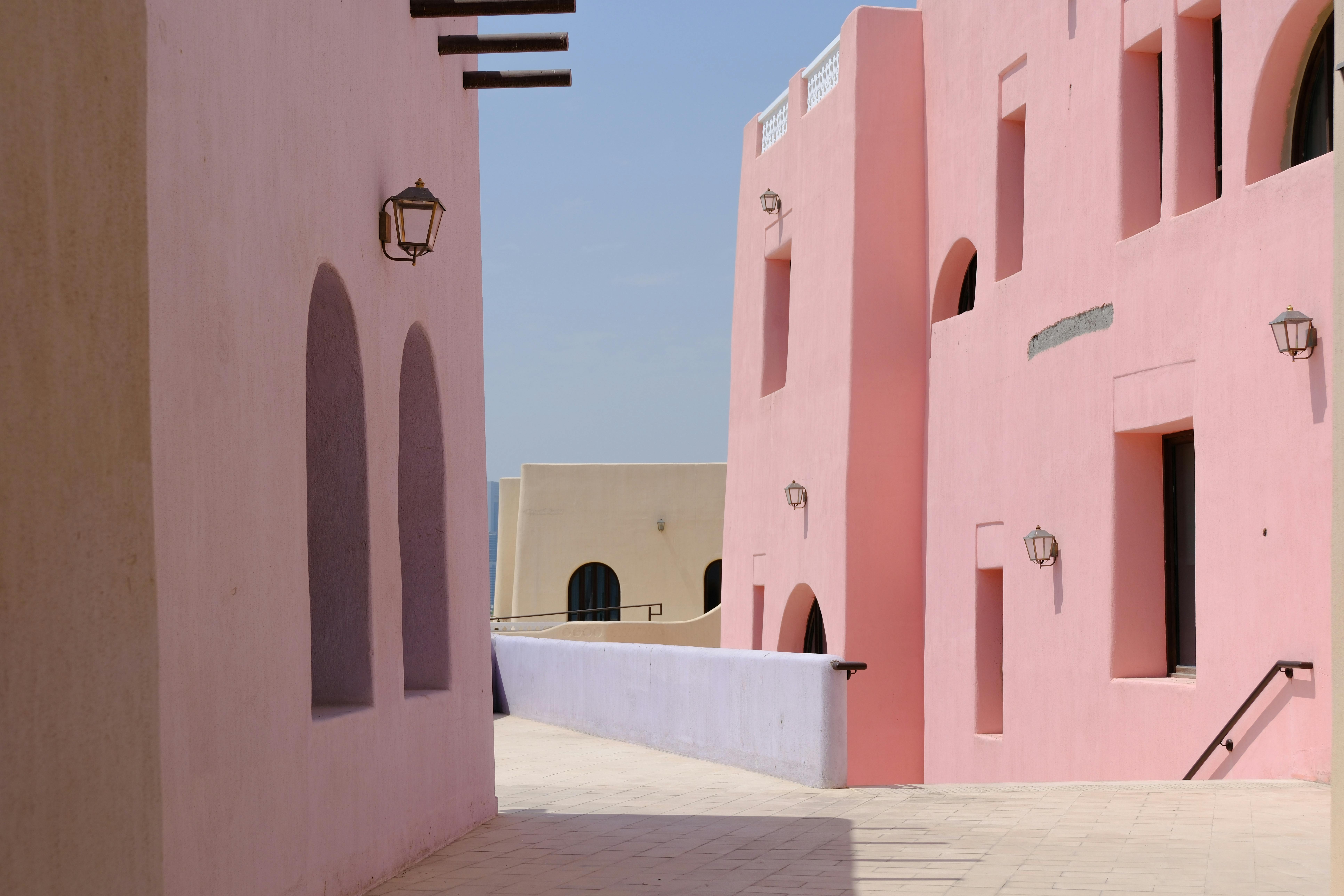 Vibrant pastel buildings with arched windows in a sunny Mediterranean style.