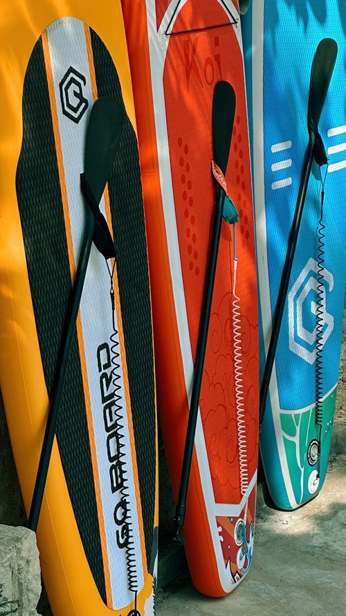 Free Colorful paddleboards lined up in the sun at La Gi beach, Vietnam. Stock Photo
