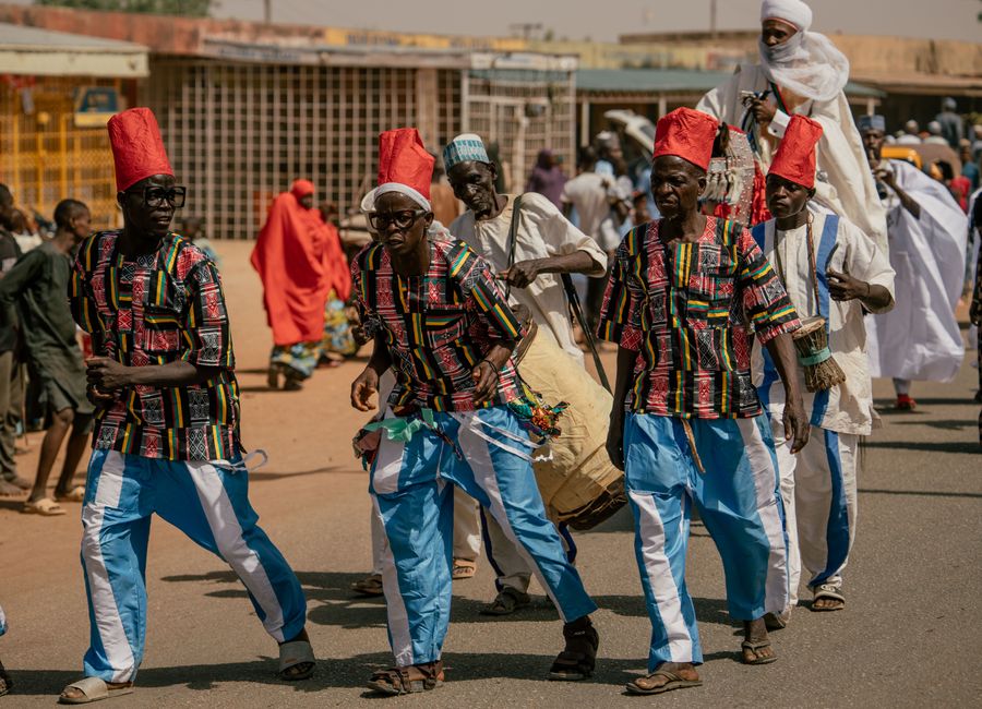 Vibrant cultural parade with people in traditional attire and drums.