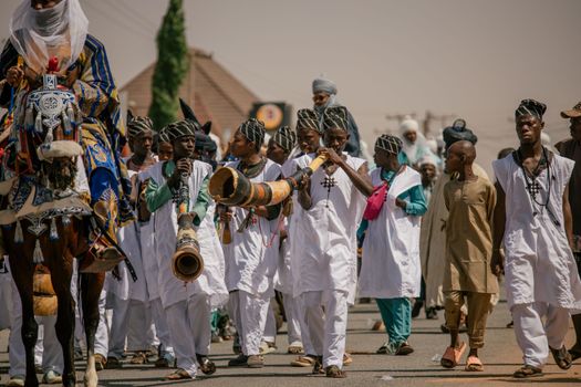 Festive parade in Nigeria featuring traditional attire and musical performances.