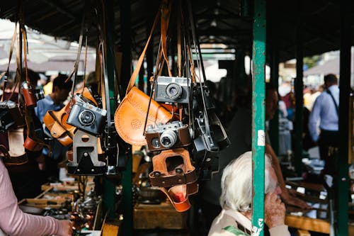 People Standing Near Store and Different Cameras Hanging