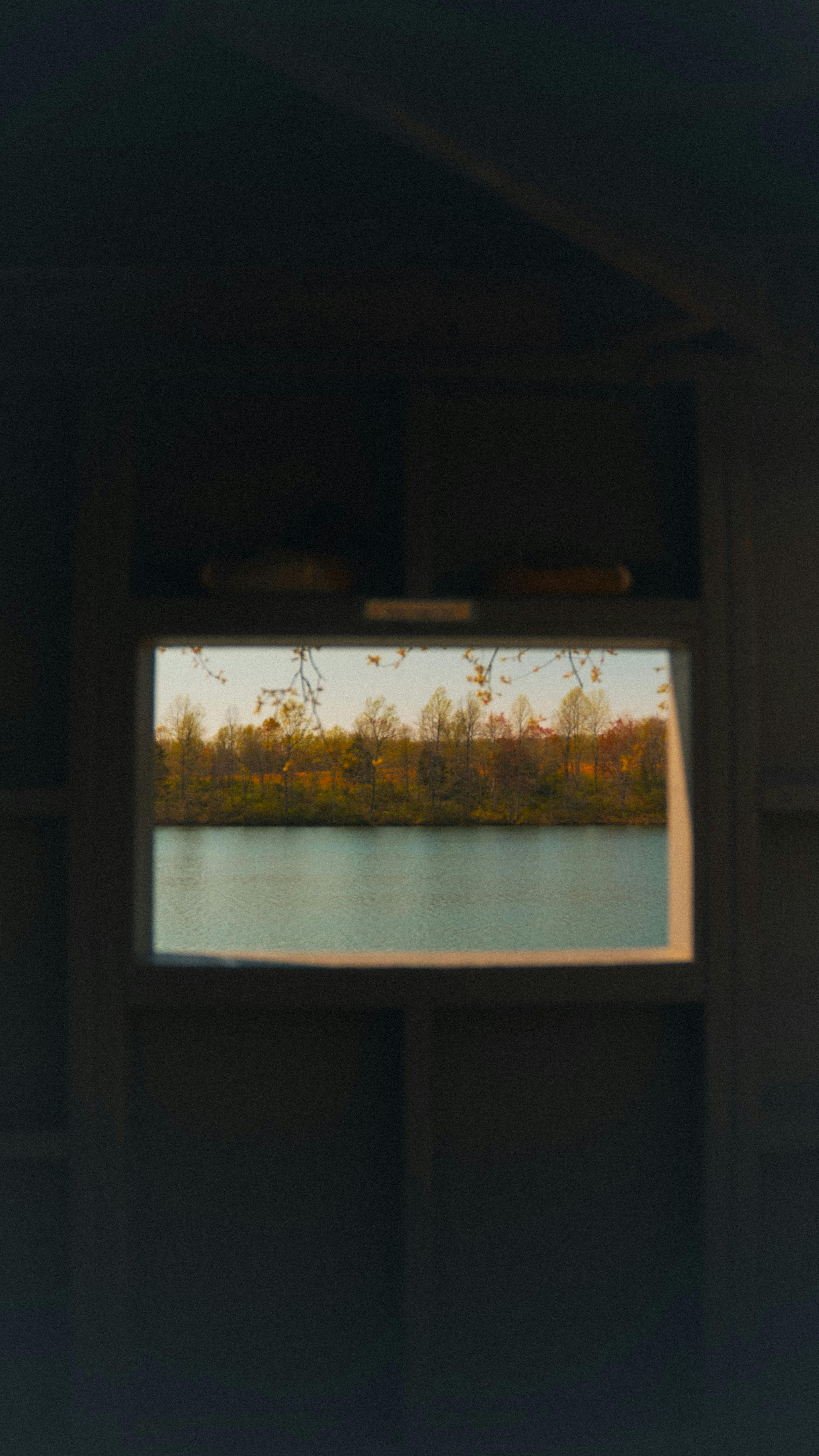 Bezpłatne Spokojny jesienny krajobraz widoczny z okna kabiny i z widokiem na spokojne jezioro. Zdjęcie z galerii