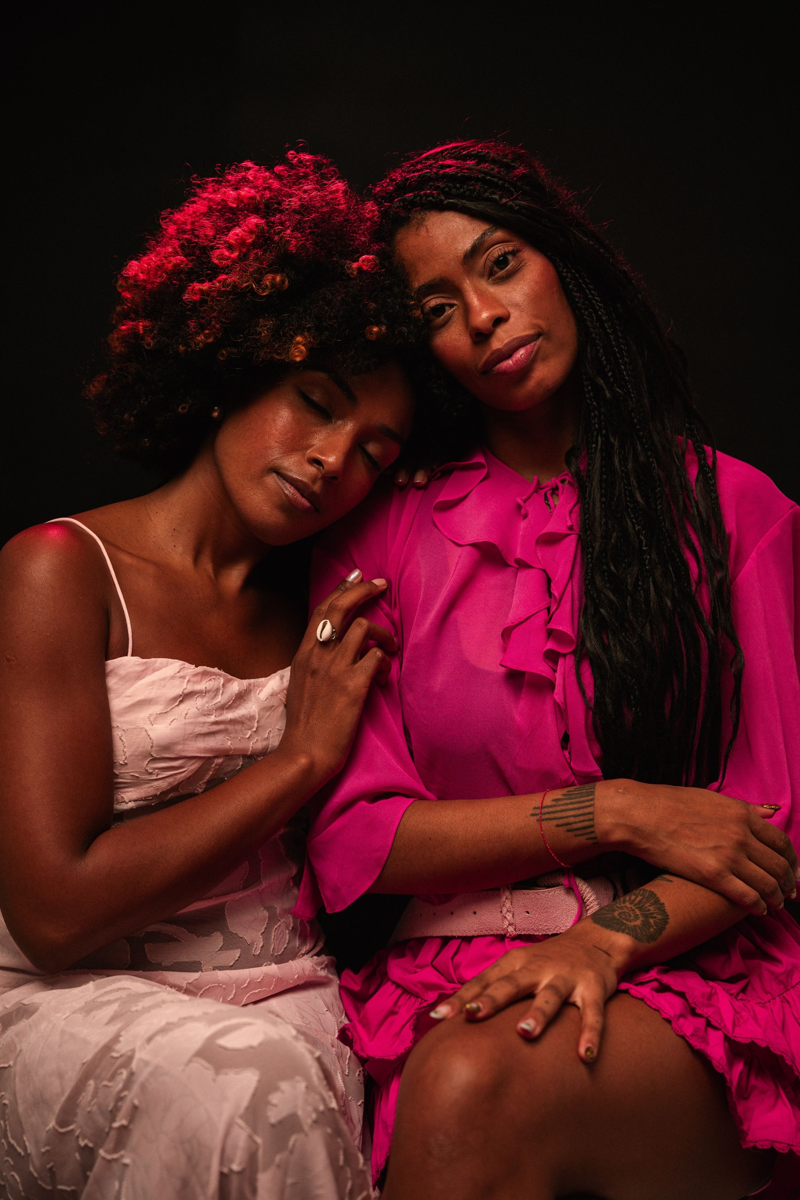 Intimate portrait of two women in vibrant clothing, capturing a tender moment.