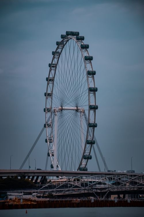 Free A view of the iconic Singapore Flyer Ferris wheel under a cloudy sky, showcasing architectural beauty. Stock Photo