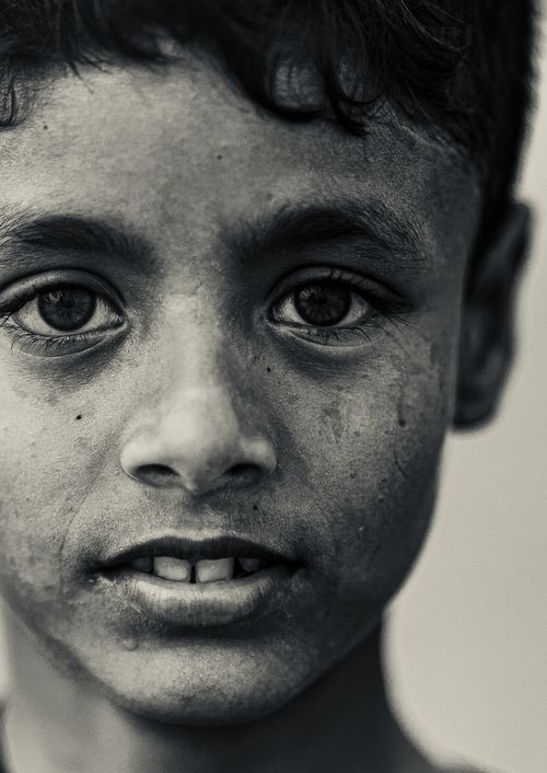Free Close-up black and white portrait of a boy with an intense gaze, showcasing emotion and innocence. Stock Photo