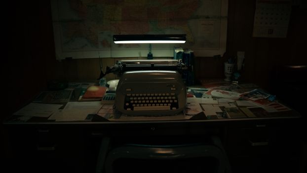 A classic office scene with a vintage typewriter on a cluttered desk under soft lighting.