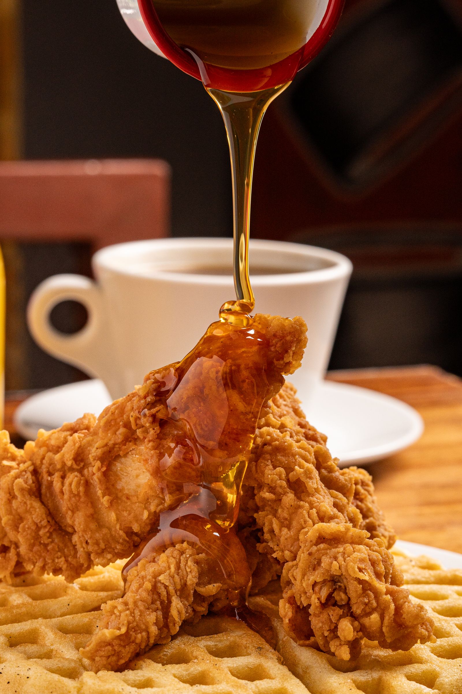 Crispy fried chicken and waffles drizzled with syrup, similar to Chick-fil-A's new chicken and waffles sandwich