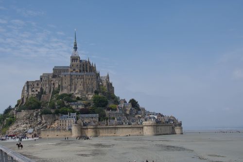 Free Explore the breathtaking Mont Saint-Michel during low tide with its iconic spire and medieval architecture. Stock Photo