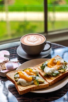 Delicious open-faced breakfast sandwiches with poached eggs and latte.