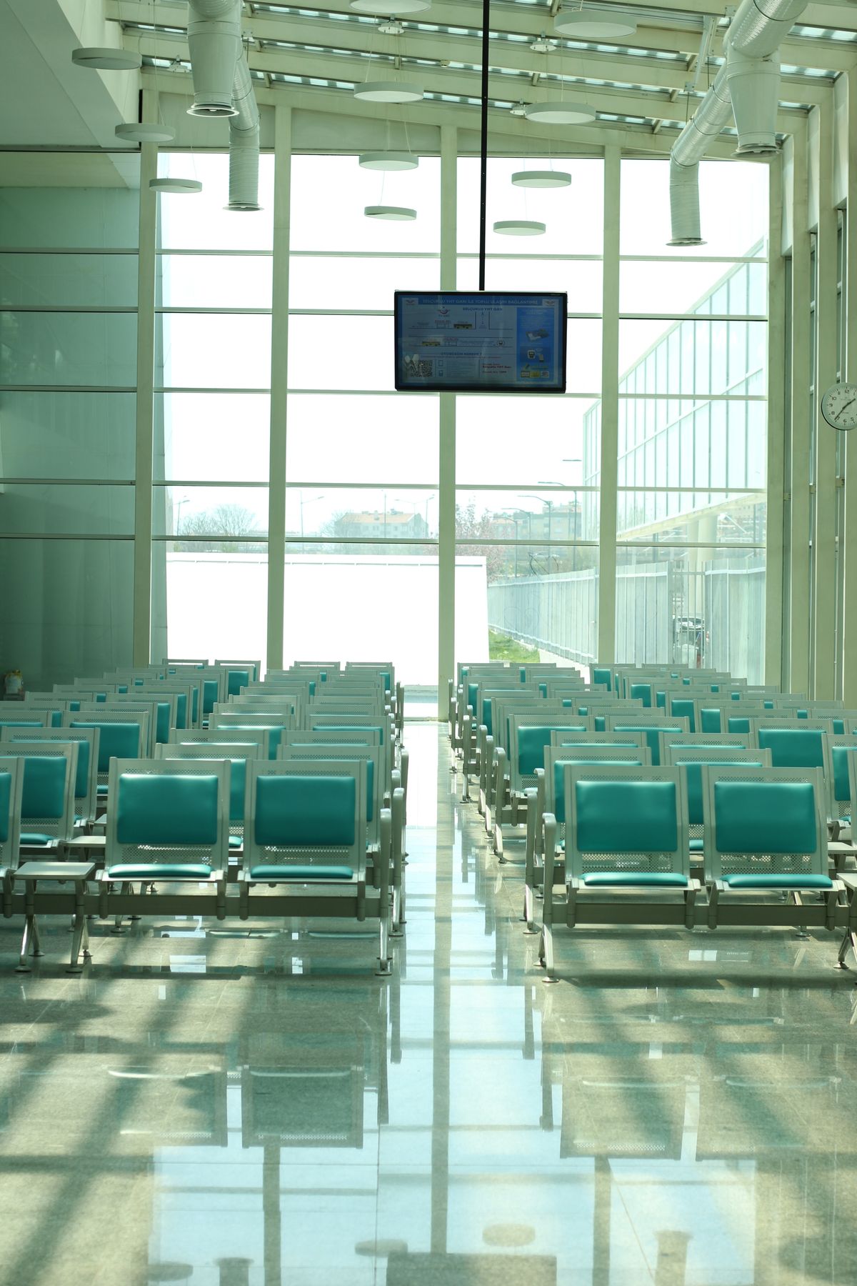 A bright, modern airport waiting area with rows of empty seating