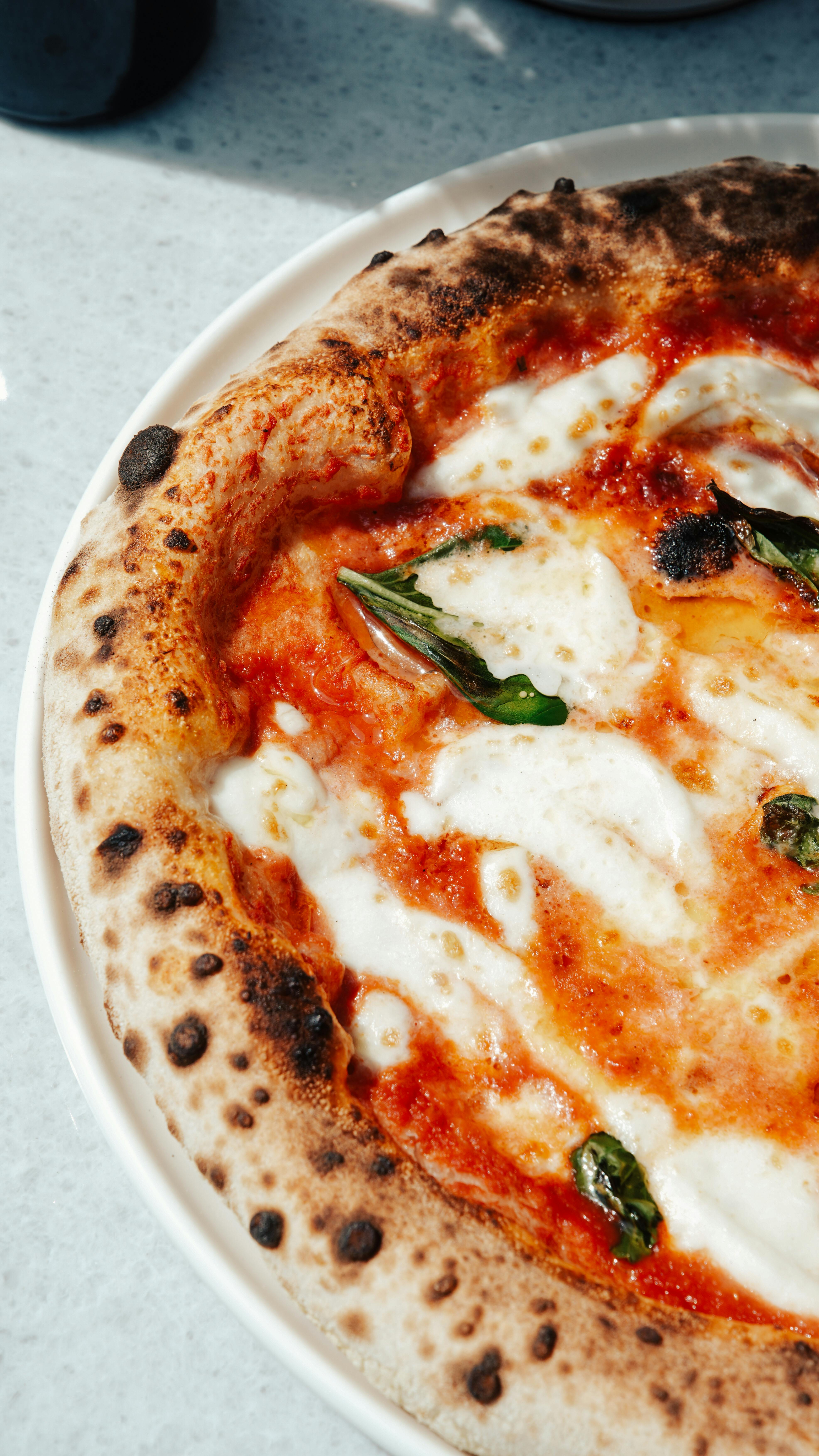 Close-up of a delicious Margherita pizza with basil, mozzarella, and tomato sauce.