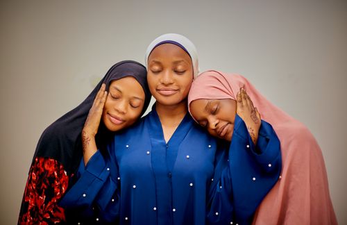 Free Three women in traditional attire with closed eyes symbolize unity and peace. Stock Photo