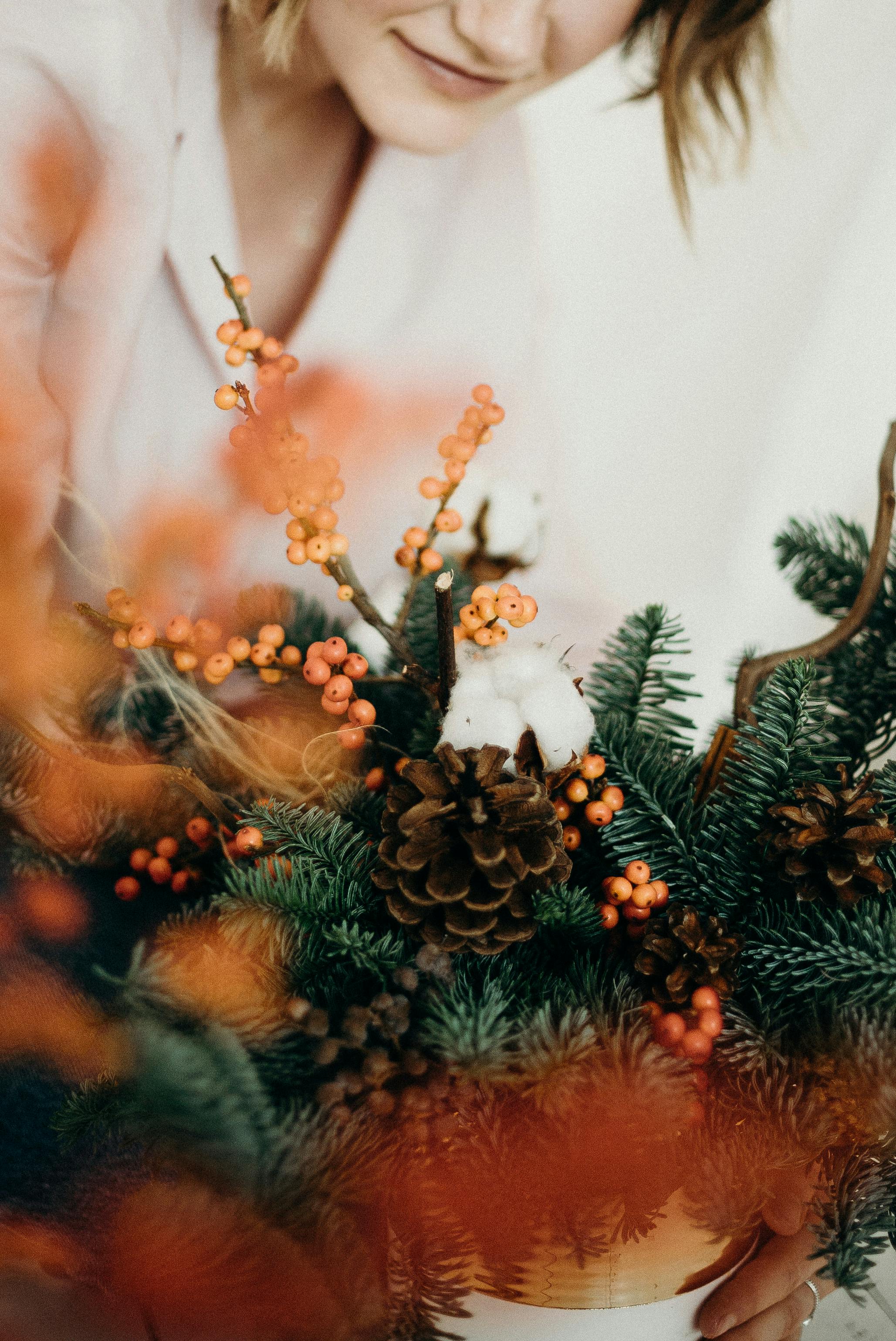 一幅节日圣诞插花的特写镜头，细节中可见松果与浆果