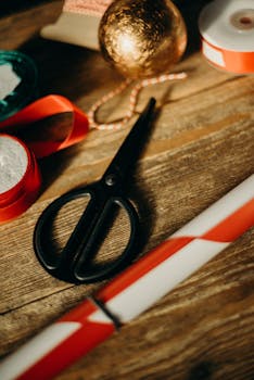 木桌上，节日礼物包装材料的特写，包括剪刀和丝带