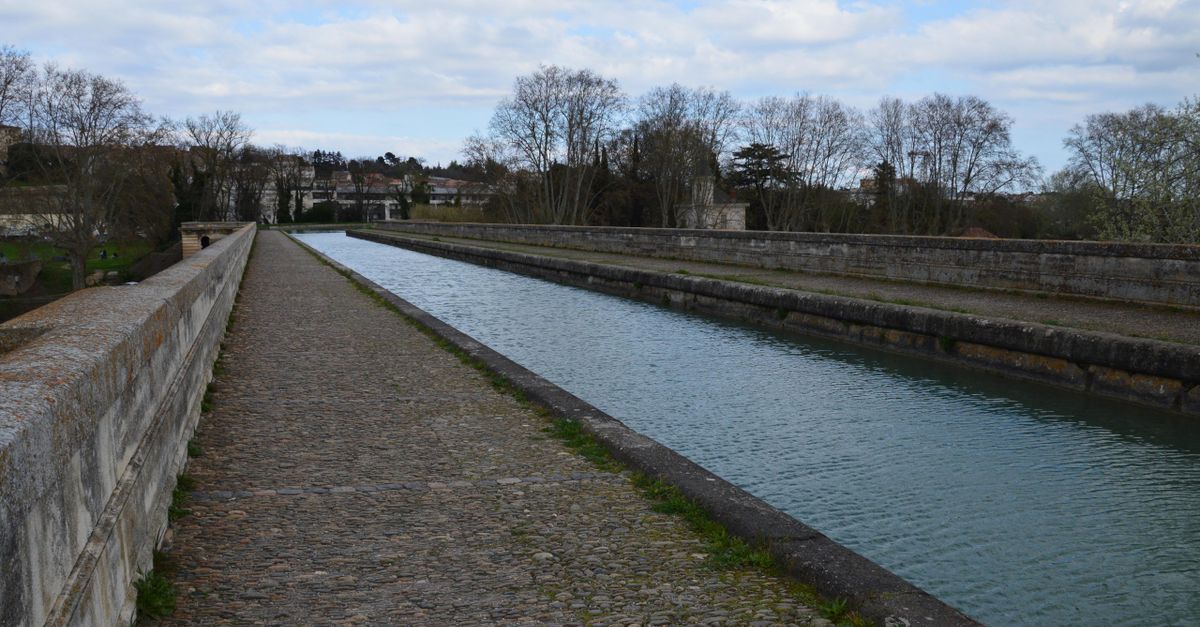 Vue pittoresque de l'aqueduc du Canal du Midi à Béziers, mettant en valeur l'eau sereine et la maçonnerie rustique.