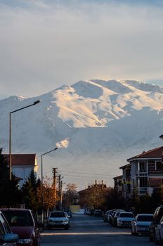 Serene sunset view of a quiet mountain town with snow-capped peaks. 31708884