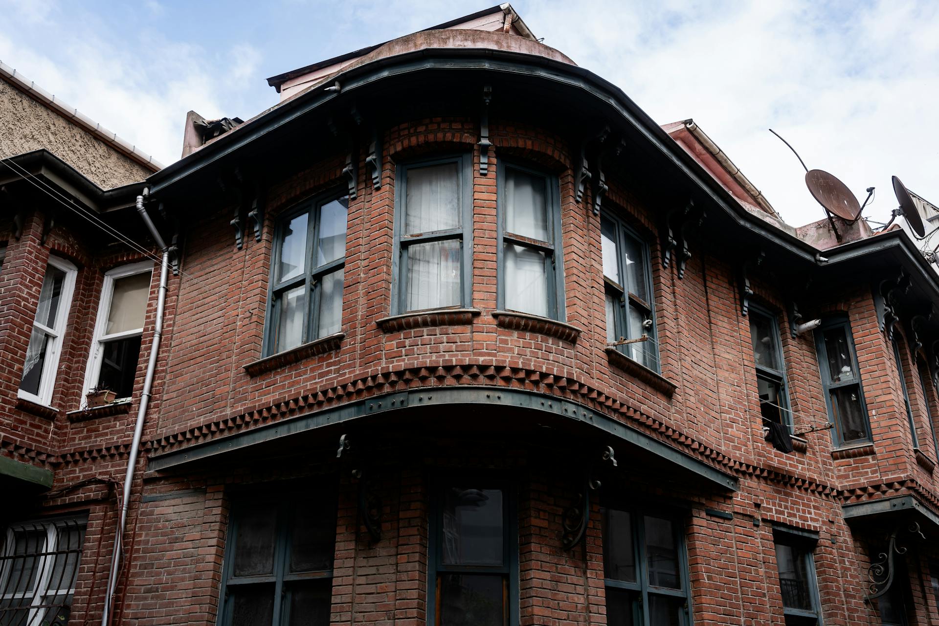 A detailed view of an old brick building showcasing unique architectural design.