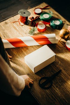 用丝带、剪刀和木桌上的装饰品包装礼物的温馨场景