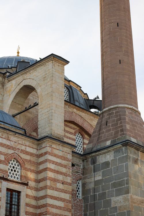 Free Exterior view of an Ottoman mosque featuring a minaret and domes. Stock Photo