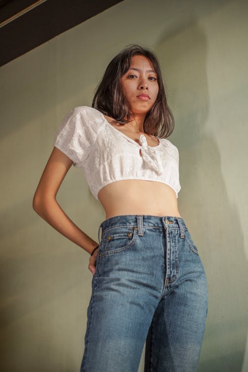 Woman in White Button Up Shirt and Blue Denim Jeans