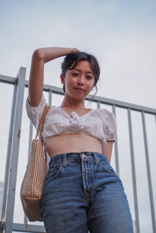 Woman in White Lace Crop Top and Blue Denim Jeans