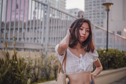 Woman in White Crop Top  Standing Near Green Plants