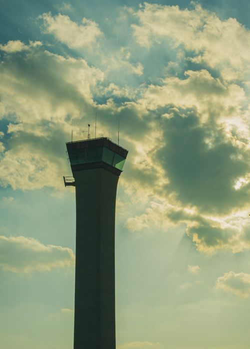 Free Silhouette of an airport control tower with a dramatic sky and clouds. Stock Photo