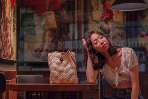 Woman in White Top sitting beside a table