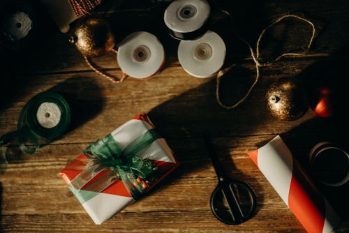 Free A rustic setup for wrapping Christmas gifts with colorful ribbons and decorations. Stock Photo