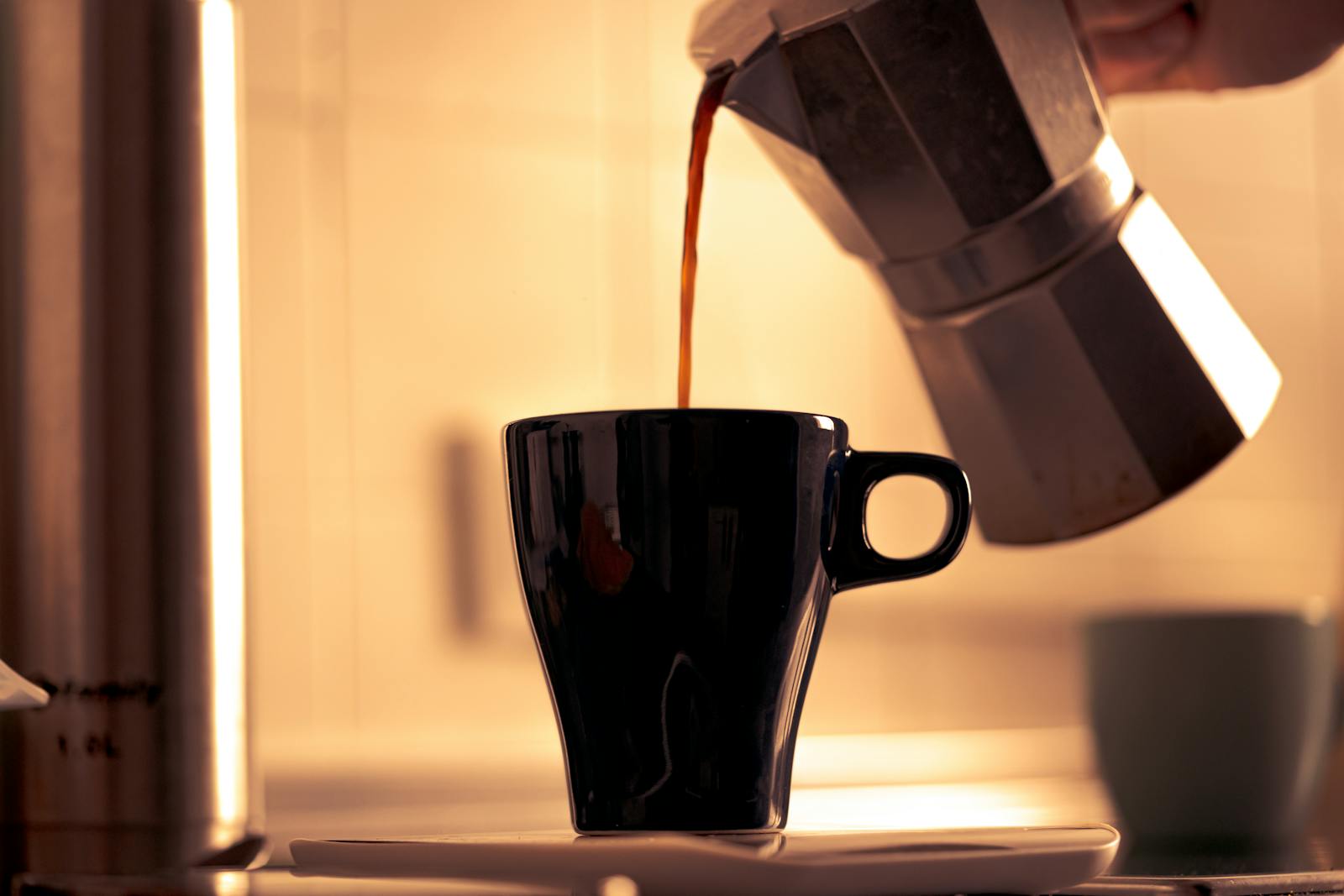 Morning coffee poured into mug near window light