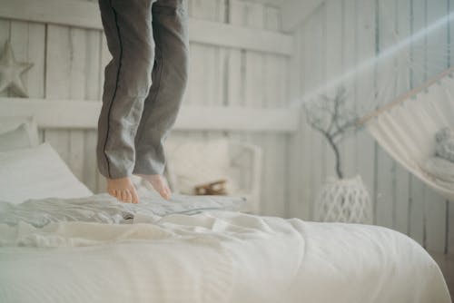 침대에서 점프하는 사람