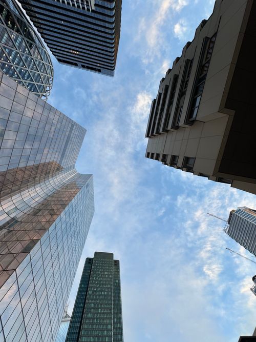 Free Upward view of modern skyscrapers against a clear blue sky. Stock Photo
