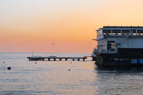 Free Peaceful sunset by a seaside pier with calm waters and serene ambiance. Stock Photo