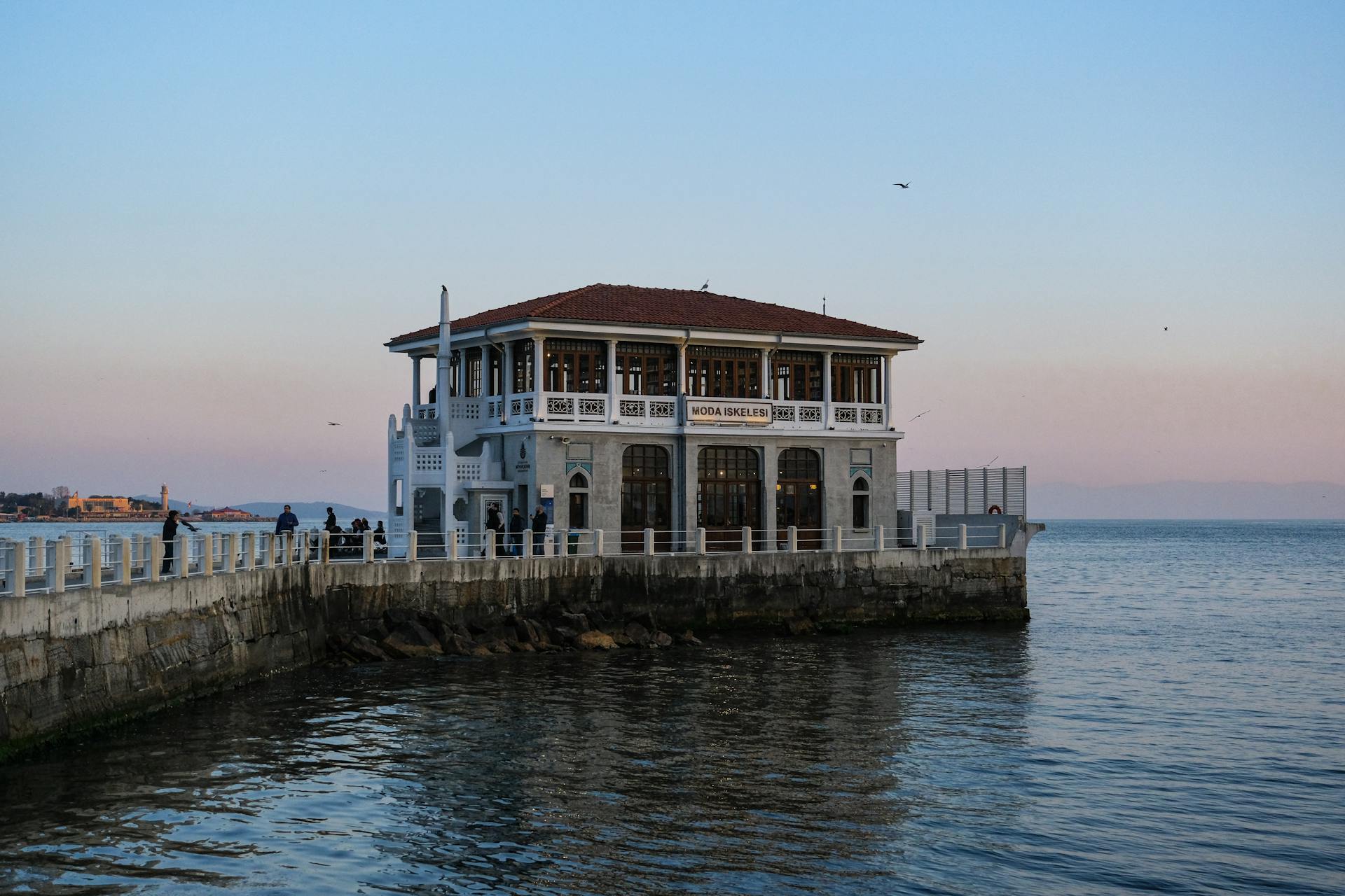 Moda Pier in Istanbul at sunset, overlooking calm waters and the skyline.