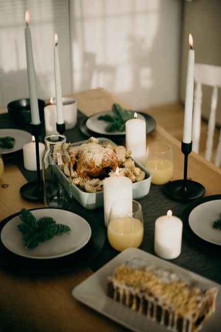 Inviting dining setup with candles, roast chicken, and cake, perfect for a festive holiday gathering.
