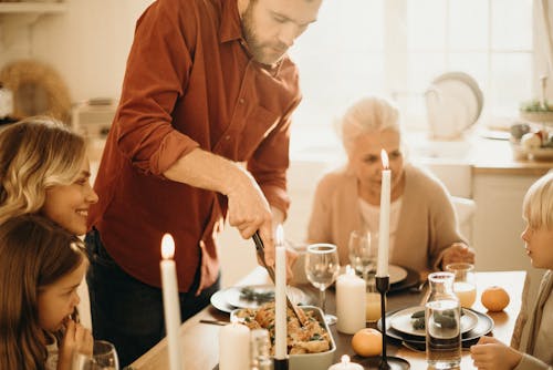 Free Selective Focus Photography of Man Preparing Food Beside Smiling Women and Kids Stock Photo