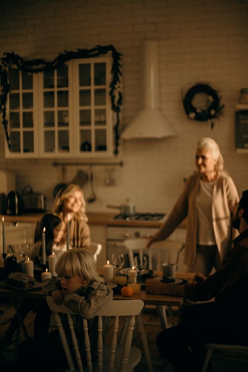 Free Warm family gathering in a cozy kitchen setting, celebrating the holidays with dinner and decorations. Stock Photo