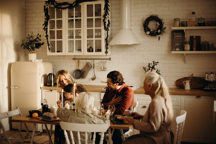 Family Sits On Table Inside Kitchen